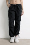 Pantalón jogger negro de mujer con cordón ajustable y zapatillas blancas