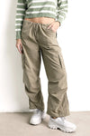 Mujer con pantalón cargo beige y suéter de rayas verdes, moda casual femenina