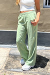 Pantalón holgado de mujer verde claro, estilo casual, con crop top blanco y zapatillas blancas