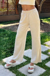 Pantalón palazzo beige de mujer con cintura elástica, estilo casual, en jardín